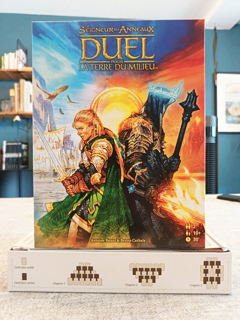 Couverture et fond de la boîte du jeu de société "Seigneur des Anneaux - Duel - La Terre du milieu". Le côté du fond de boîte montre la disposition des cartes pour chacun des 3 âges du jeu.